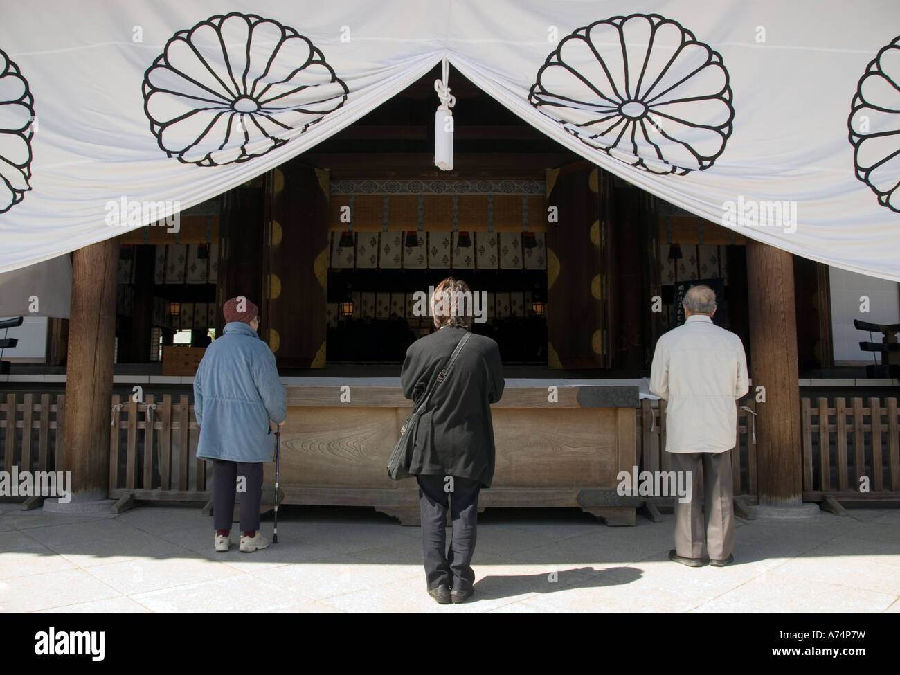 Tre persone a pregare nel Santuario Yasukuni Tokyo Foto Stock