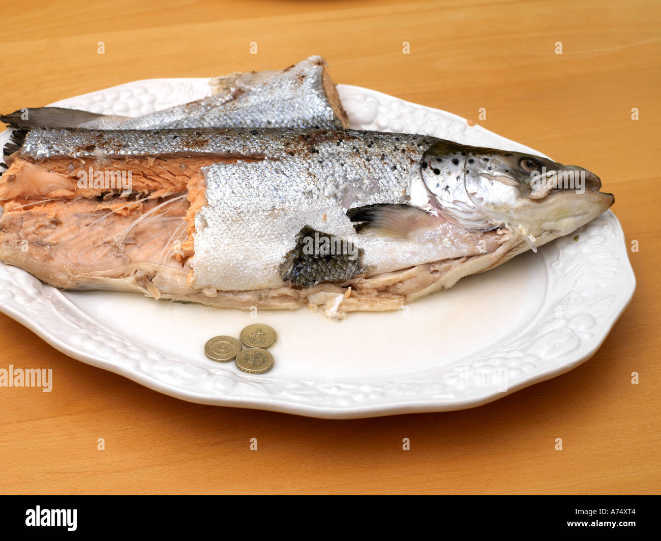 Tre monete d oro e salmone Foto Stock