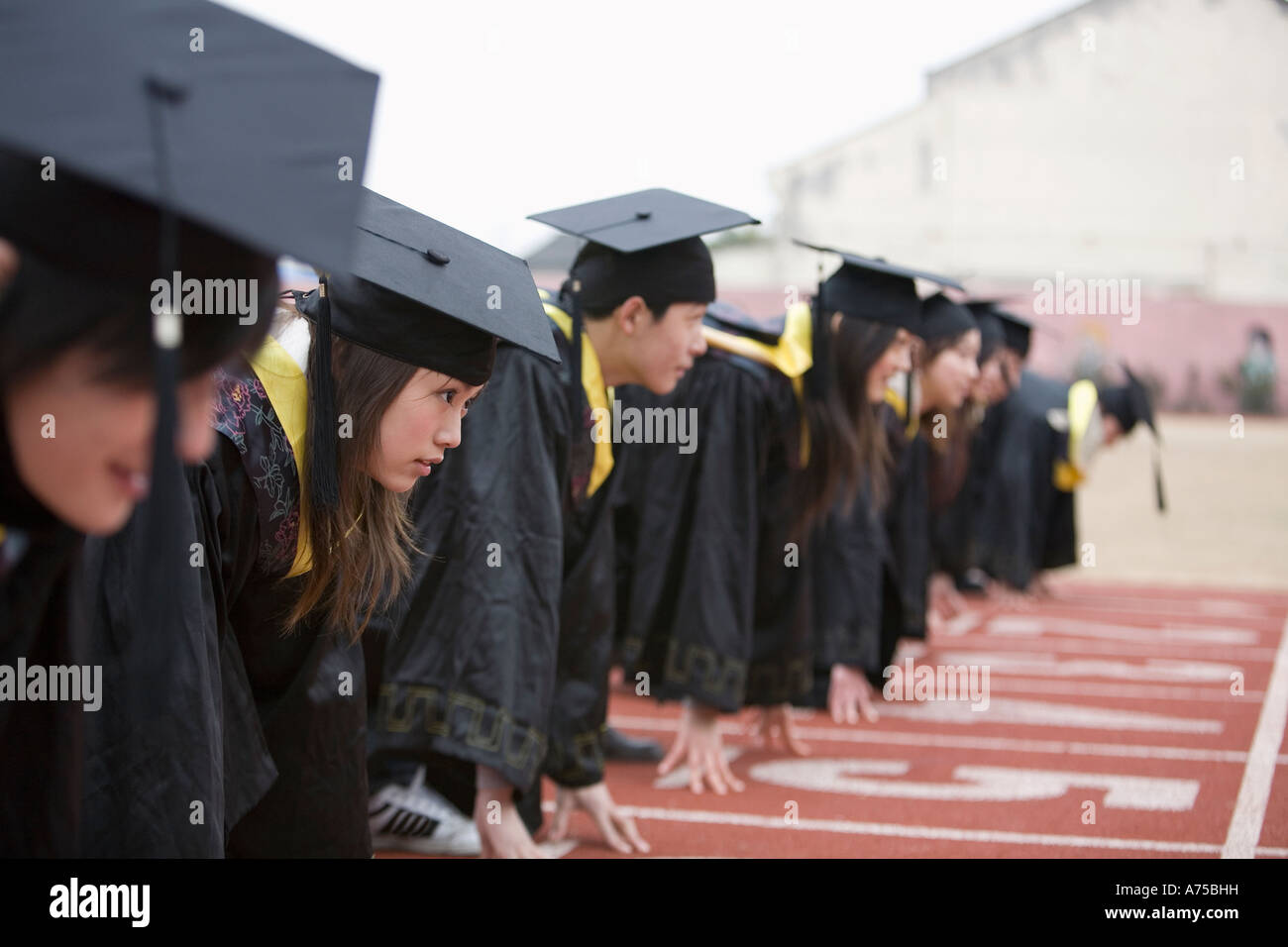 Gli studenti nelle vesti di graduazione racing Foto Stock