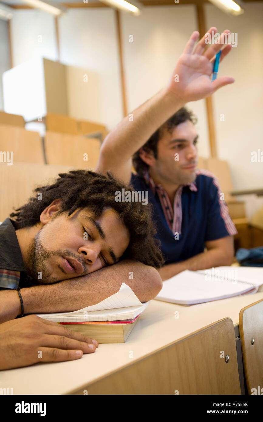 Studente maschio dorme in classe Foto Stock