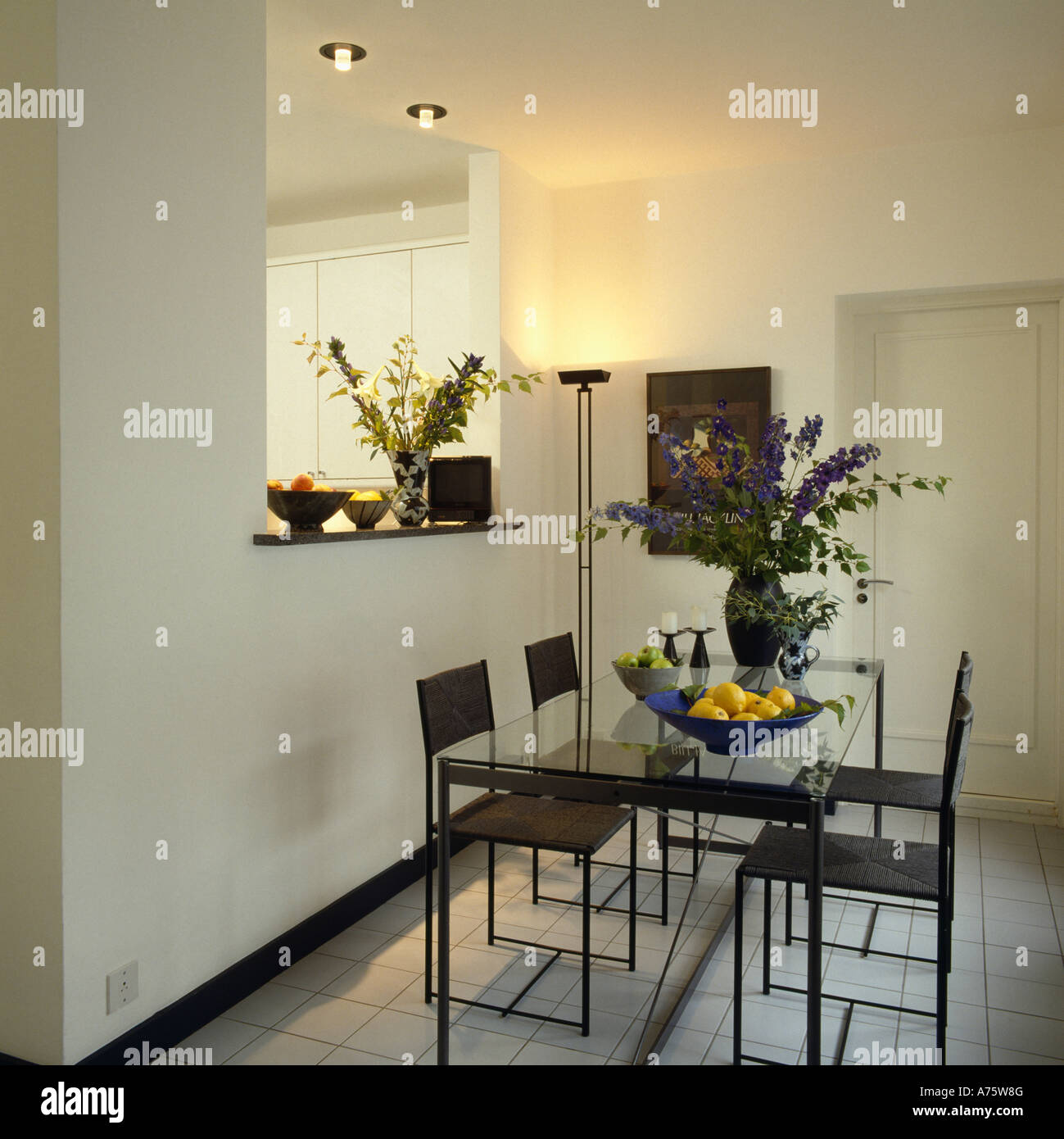 Moderna sala da pranzo in bianco nero con tavolo e sedie e uplighter nell'angolo della stanza Foto Stock