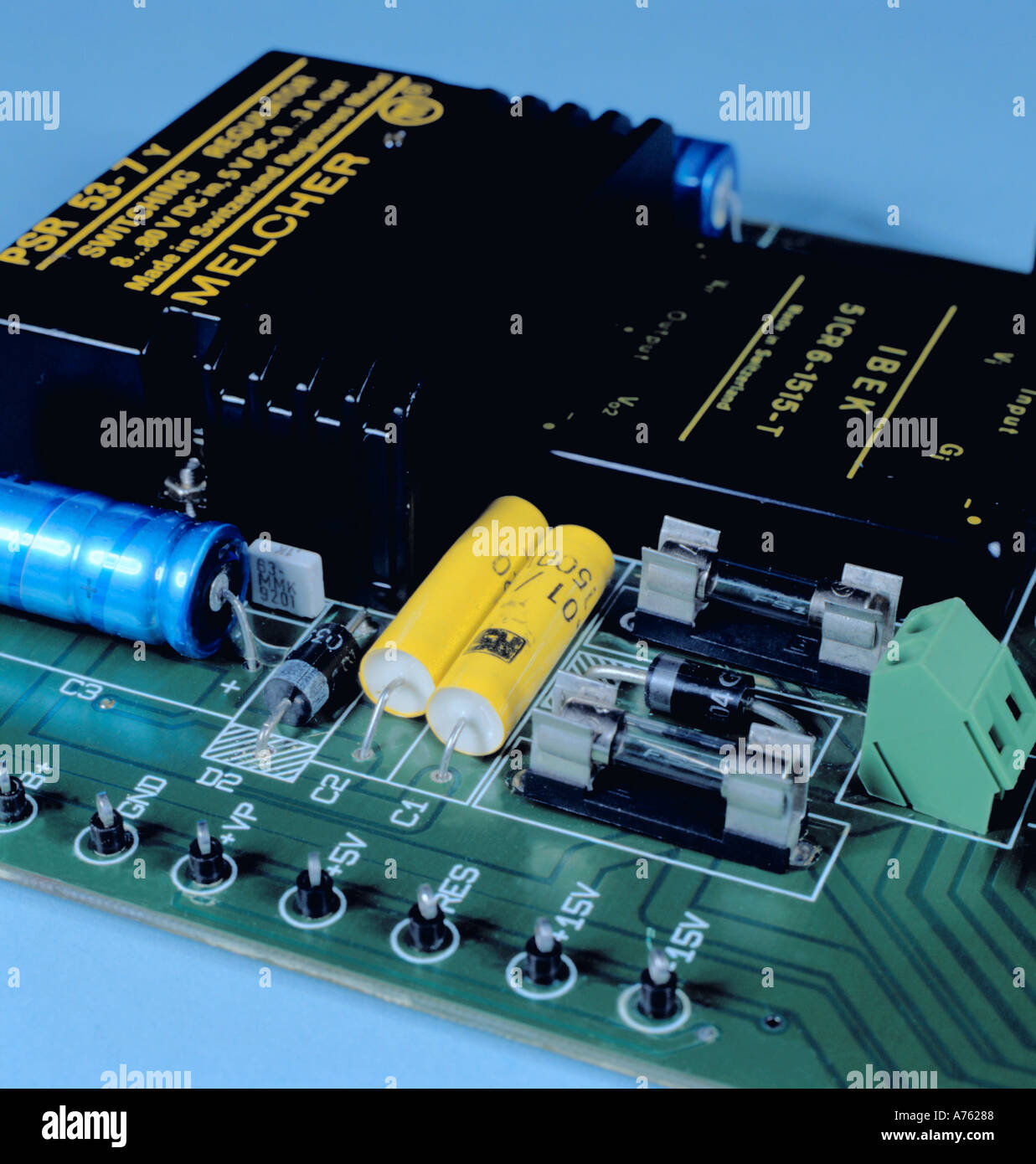 Scheda a circuito stampato con componenti elettrici (condensatori, diodi, fusibili, con un convertitore DC-DC per la parte posteriore). Foto Stock