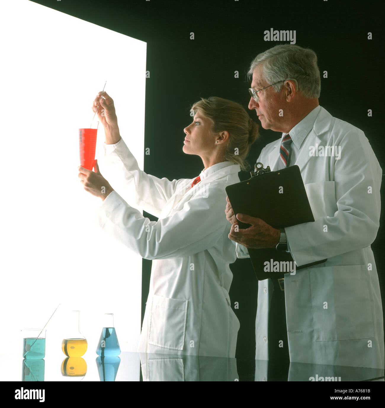 L uomo e la donna medici controllando il contenuto del bicchiere Foto Stock