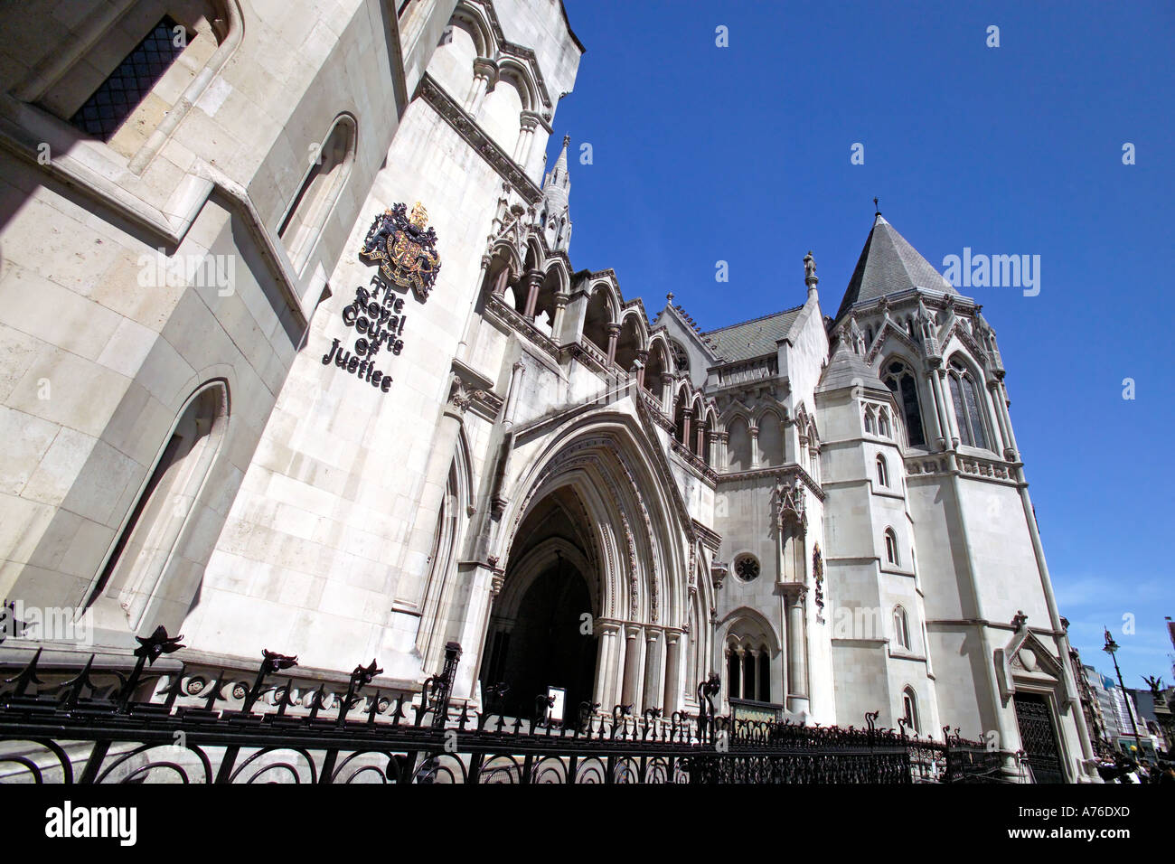 Ampio angolo di visione dell'entrata principale al Royal Courts of Justice aka Tribunali contro un cielo blu. Foto Stock