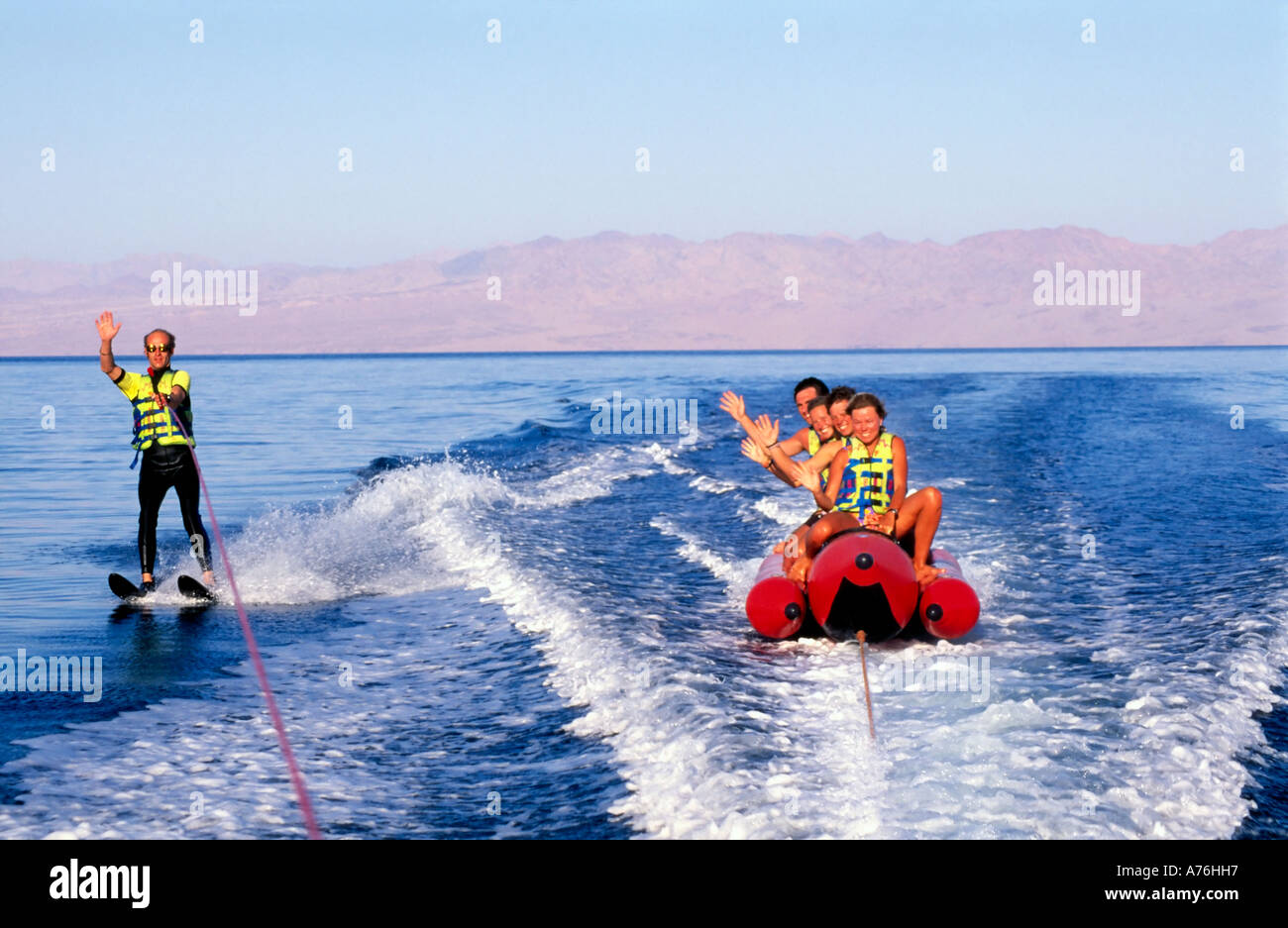 Sciatore acqua e banana boat piloti (turisti) agitando e divertirsi sul mare. Foto Stock
