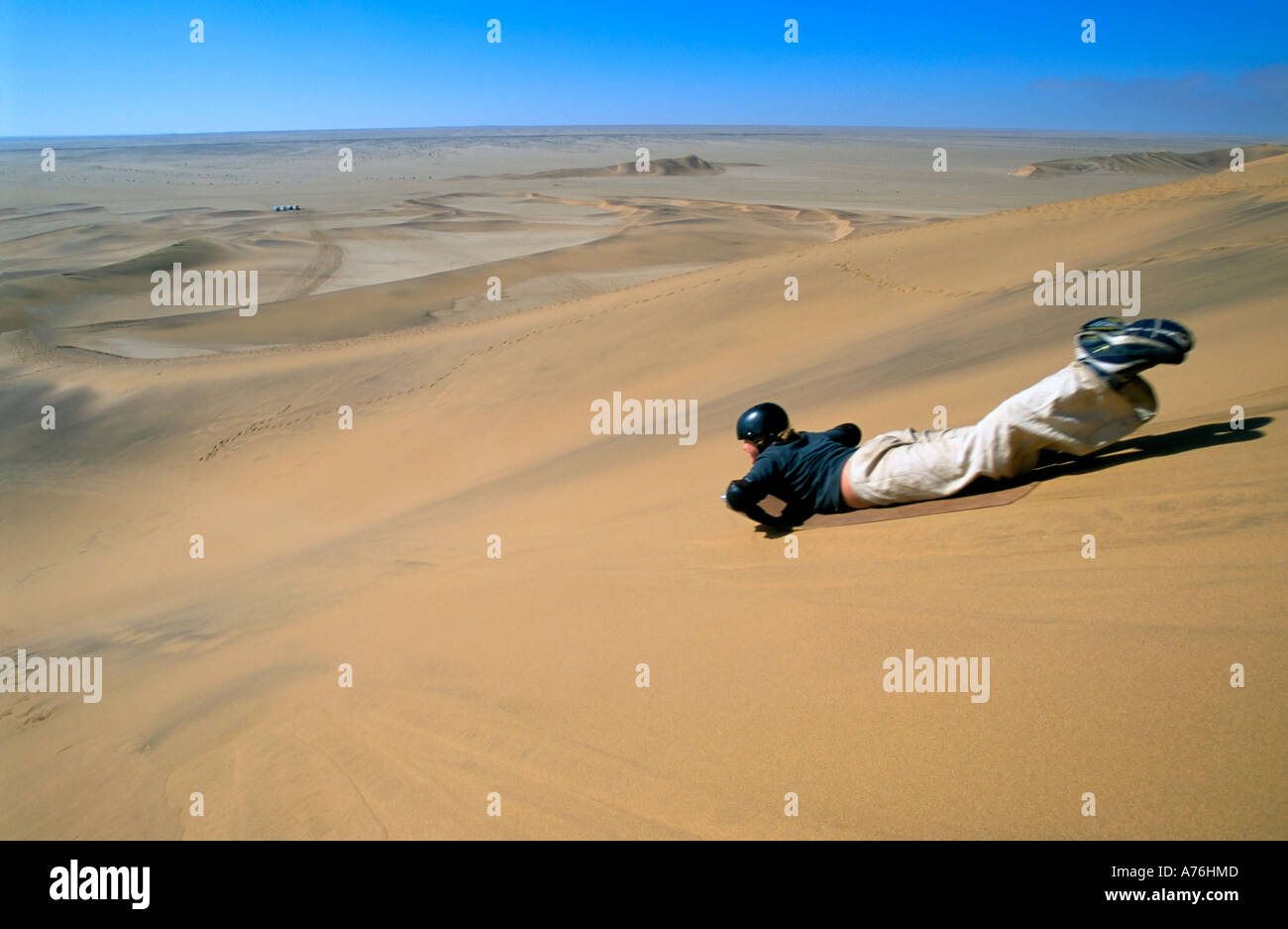 Un boarder di sabbia la discesa delle dune di sabbia della Namibia. Foto Stock