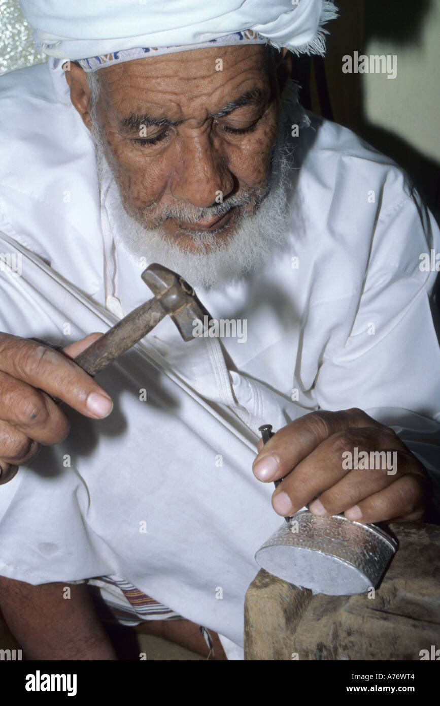 Omani argentiere Rashid Obeidani martelli un design nella carcassa di un argento, khanjar Oman tradizionale di un pugnale curvo. Foto Stock