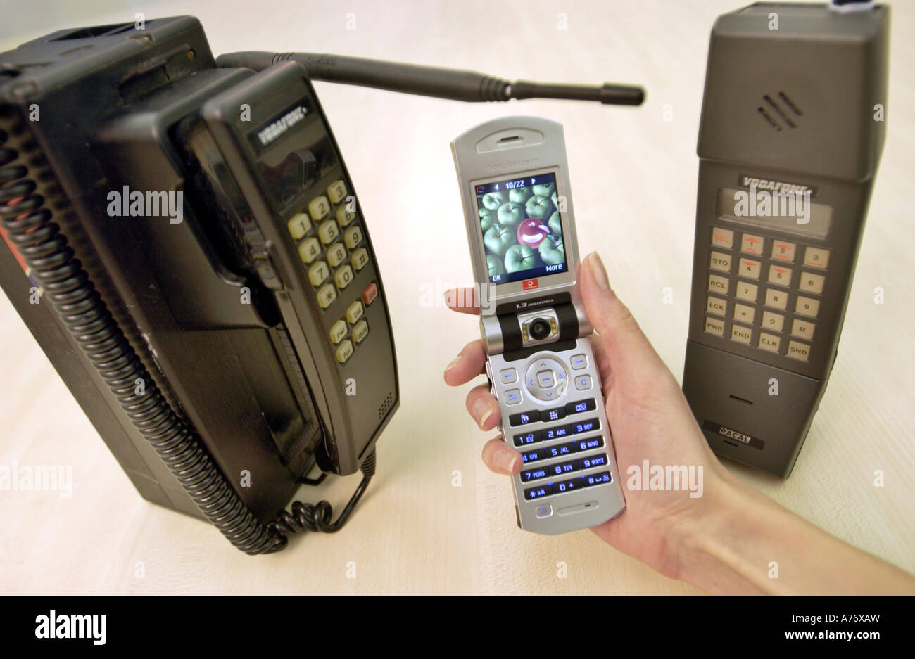 La storia dei telefoni cellulari visualizzati con i vecchi modelli da anni ottanta e un 3G videotelefono. Foto Stock