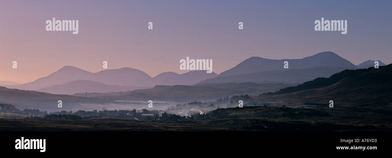 Early Morning mist su Portree e le lontane Cuillin Hills Isola di Skye in Scozia Foto Stock