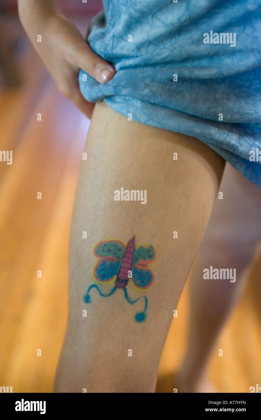 Giovane ragazza che mostra off auto inflitti butterfly dipinto sulla gamba come non tatuaggio permanente Foto Stock