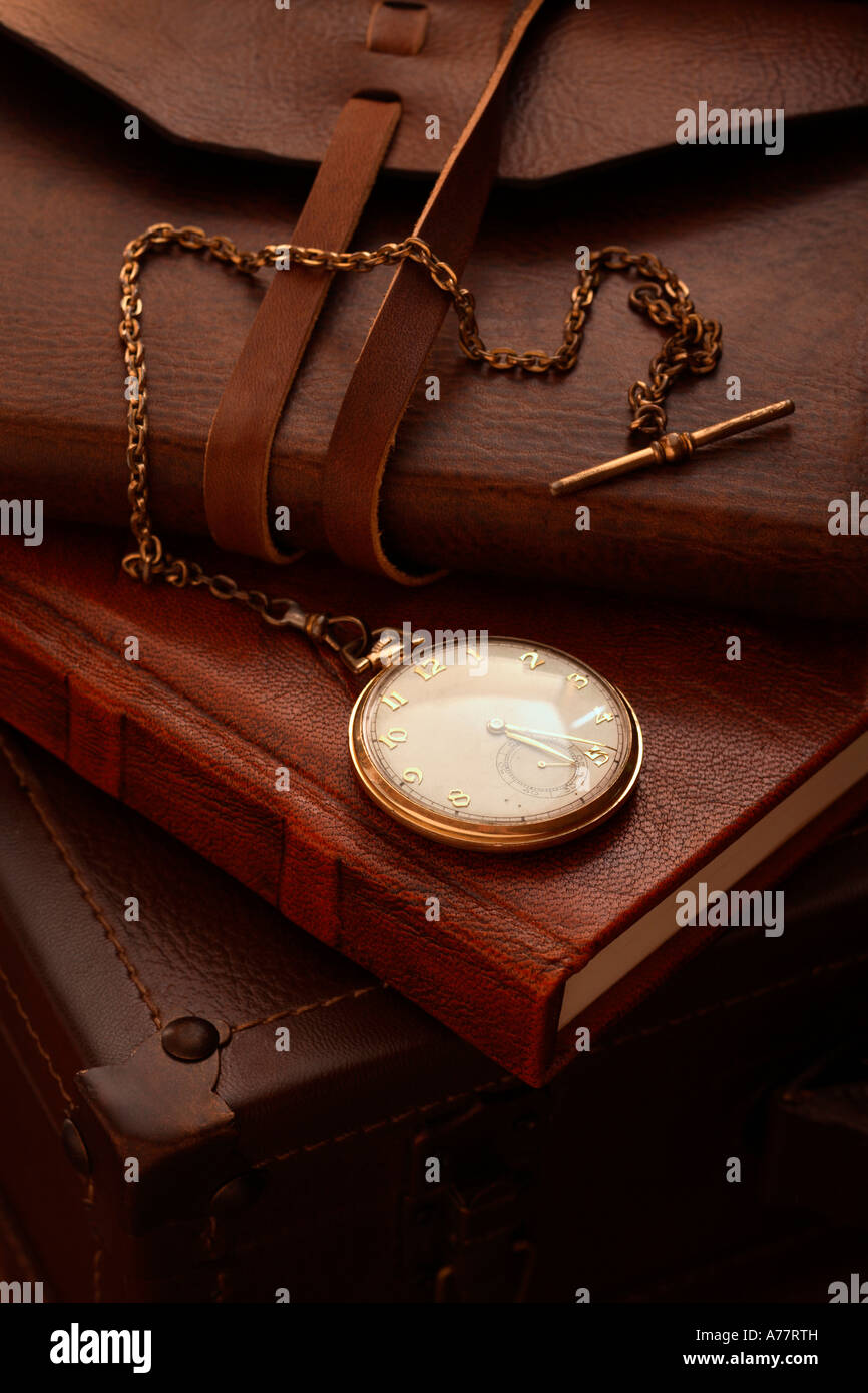 Antico orologio da tasca sulla pila di libri con copertina in pelle e casi Foto Stock
