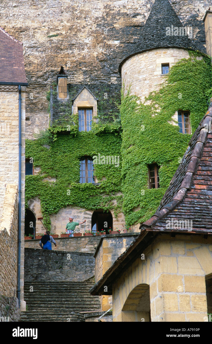 Gli uomini con scope Ivy su vecchi edifici di La Roque Gageac Dordogne Francia Foto Stock