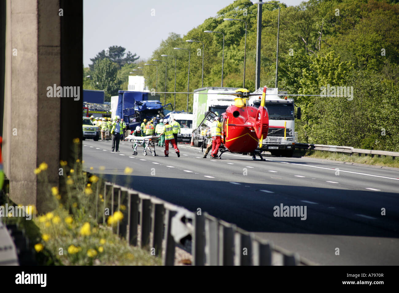 Air Ambulance elicotteri frequentando RTA sulla autostrada M6 parcheggiata su una carreggiata con i paramedici barella di scarico Foto Stock