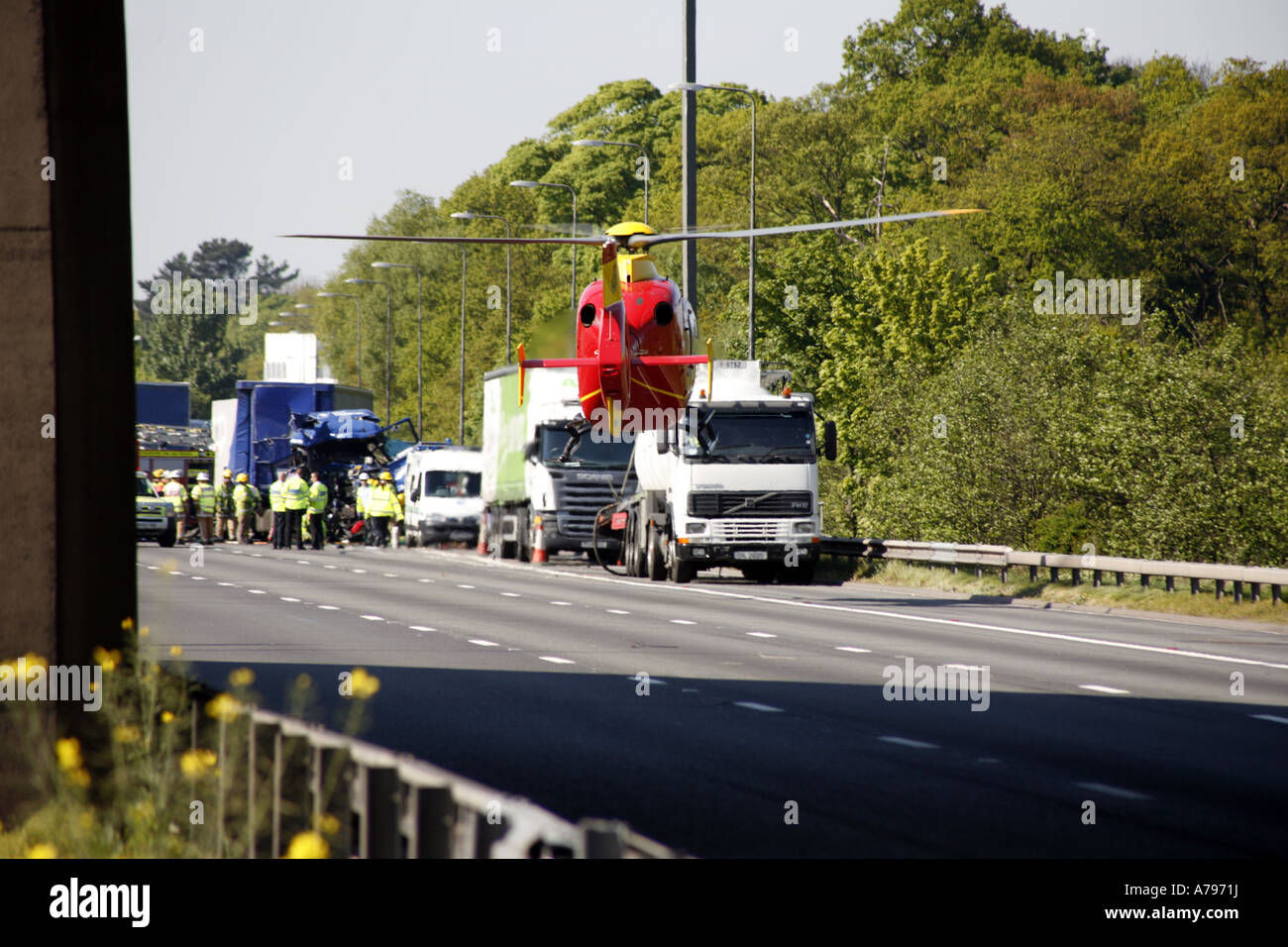 Air Ambulance elicotteri frequentando RTA sulla autostrada M6 il sollevamento fuori dalla carreggiata dopo il prelievo di feriti Foto Stock