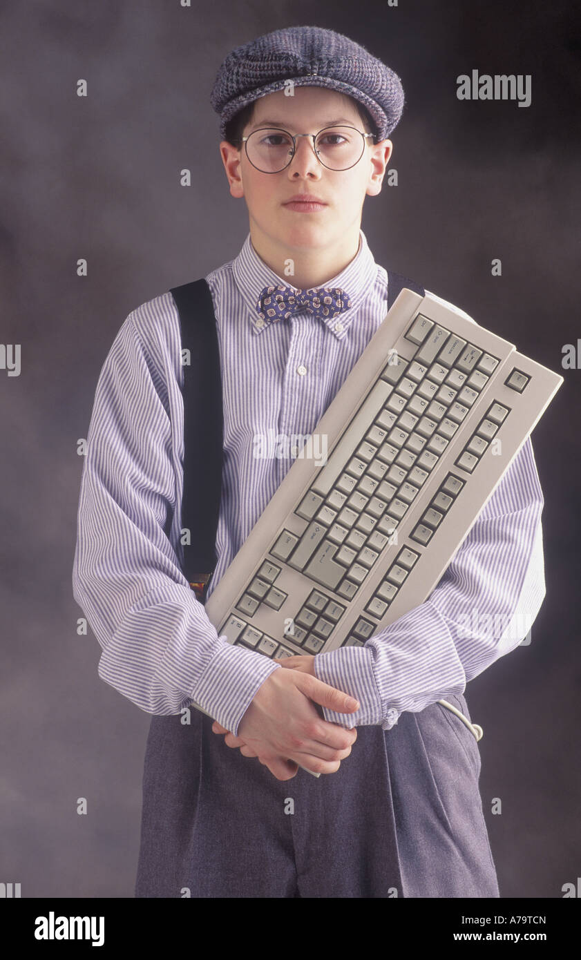 Ragazzo con gli occhiali autoreggenti, cappello e cravatta a farfalla con  la tastiera del computer Modello rilasciato Foto stock - Alamy