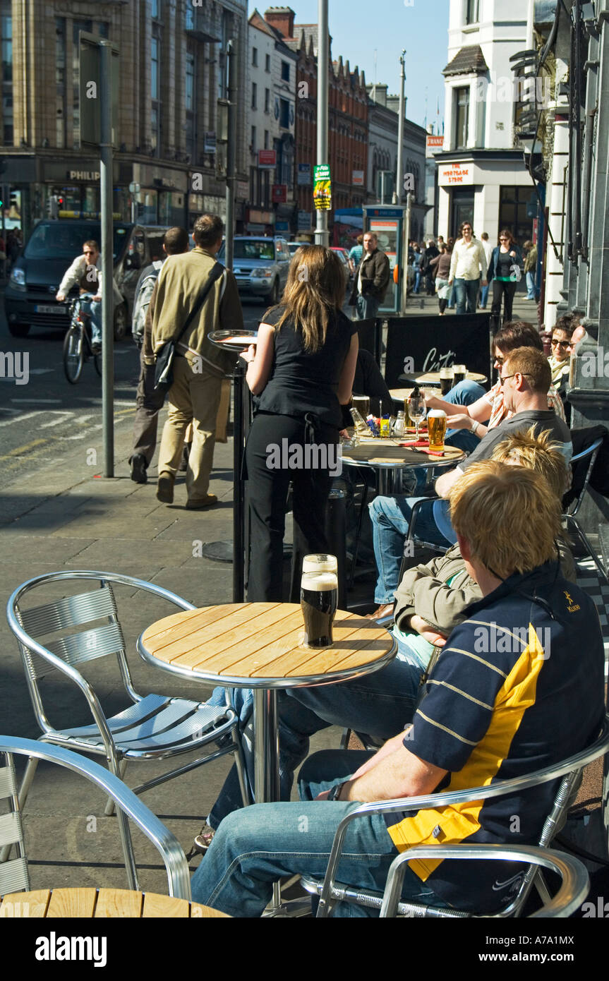 Godendo di una birra Guinness in corrispondenza di un marciapiede cafe/bar su Dame Street Dublino Irlanda Foto Stock