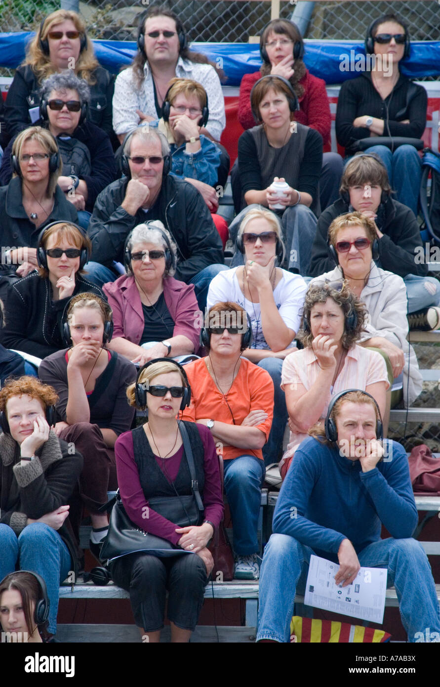 Il pubblico a un open air theatre esperienza di ascolto attentamente attraverso l'uso di cuffie Foto Stock