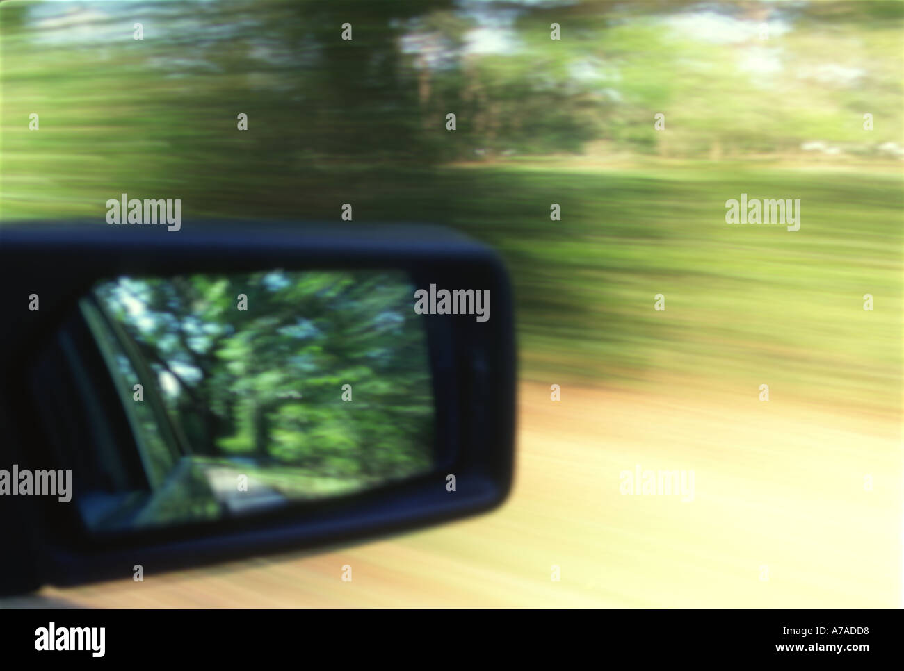 Primo piano di una vettura lo specchietto laterale viaggia su una strada di campagna abstract Foto Stock