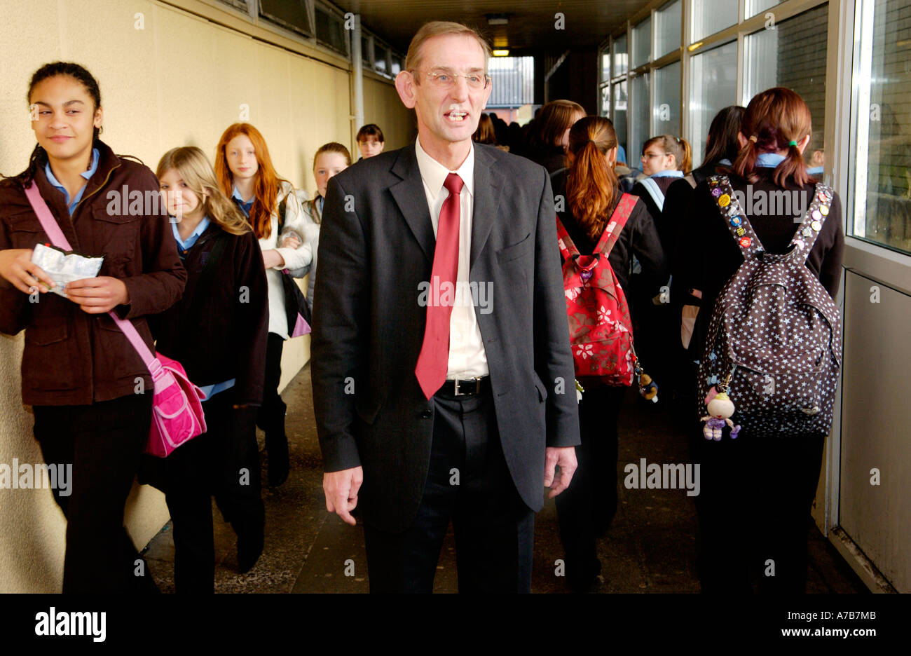 Direttore circondato dagli alunni viaggiano tra lezioni a scuola corridoio Cardiff South Wales UK GB Foto Stock