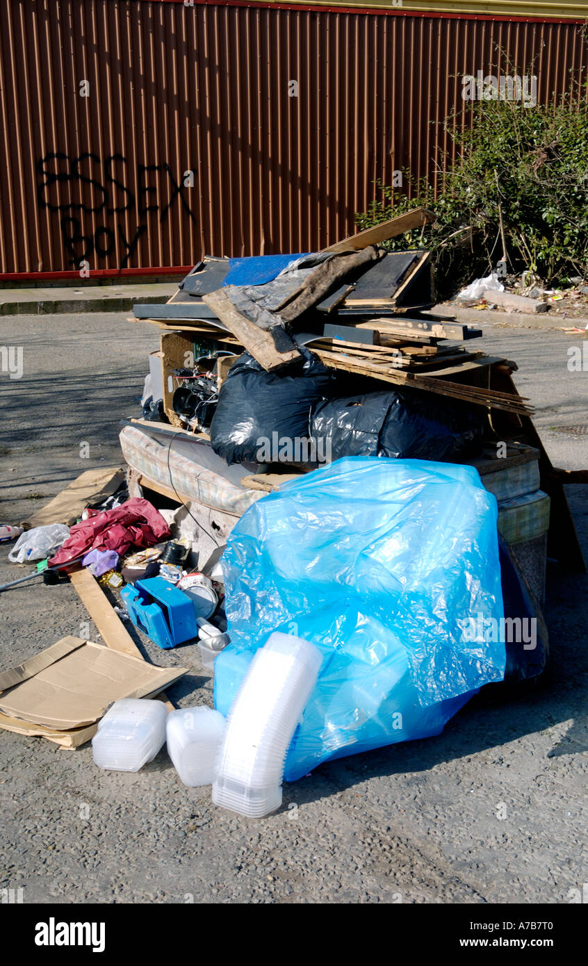 Rifiuti lasciati dai viaggiatori caravan oggetto di pratiche di dumping nel parcheggio della fabbrica in disuso Newport South Wales UK Foto Stock
