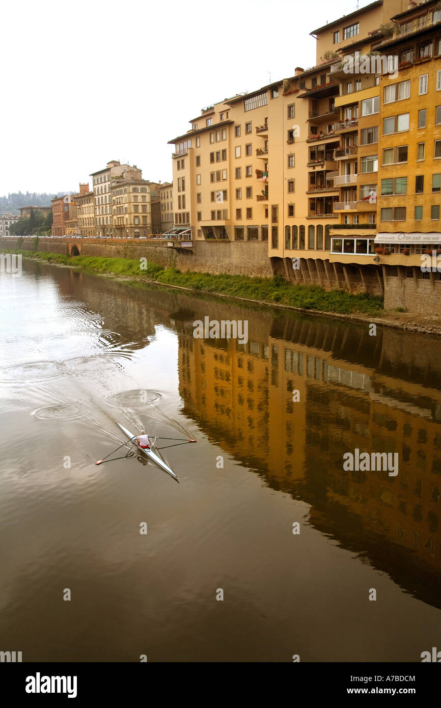 Lone diportista più righe il suo guscio lungo il fiume Arno a Firenze Italia Foto Stock