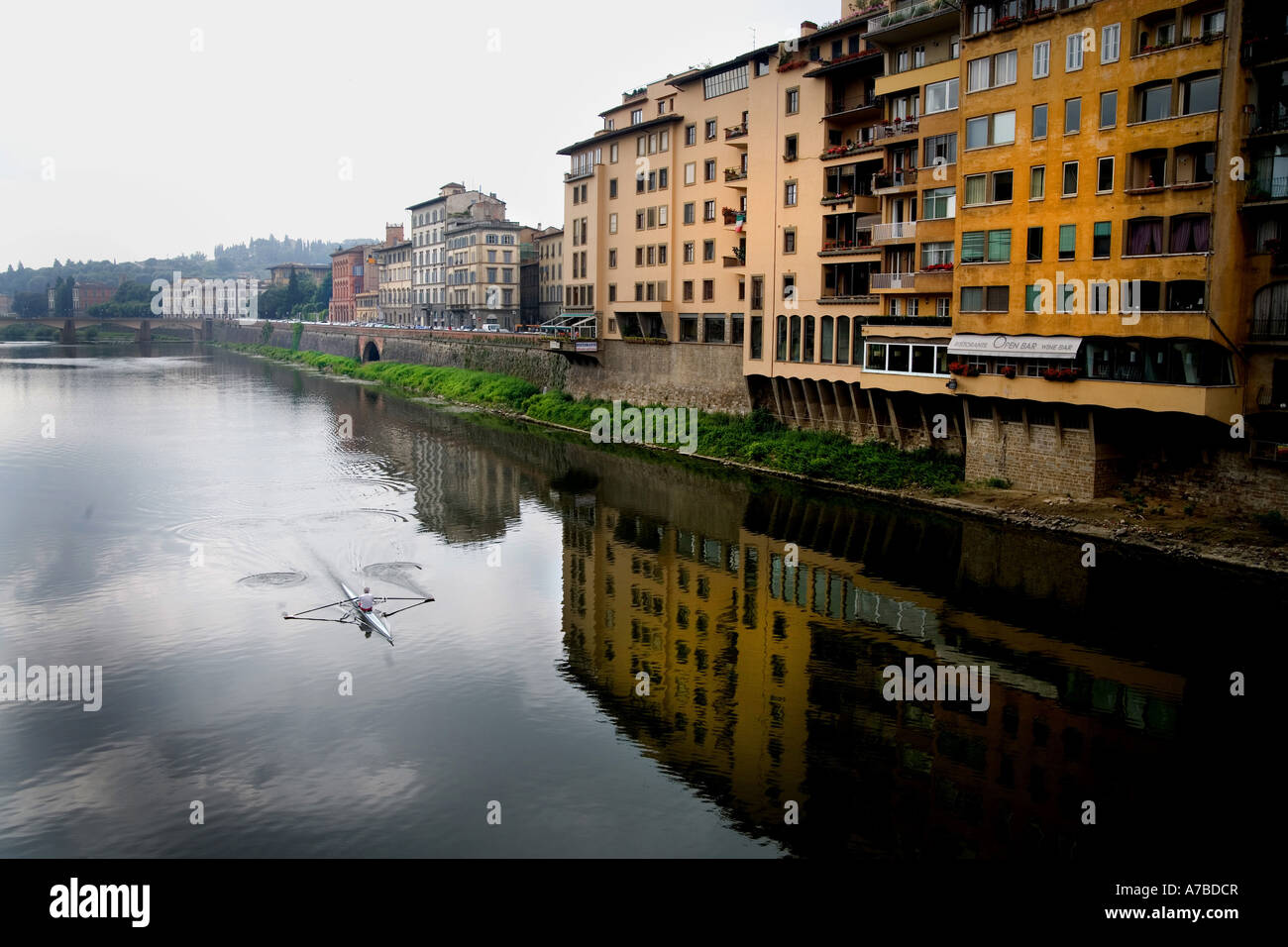 Lone diportista più righe il suo guscio lungo il fiume Arno a Firenze Italia Foto Stock
