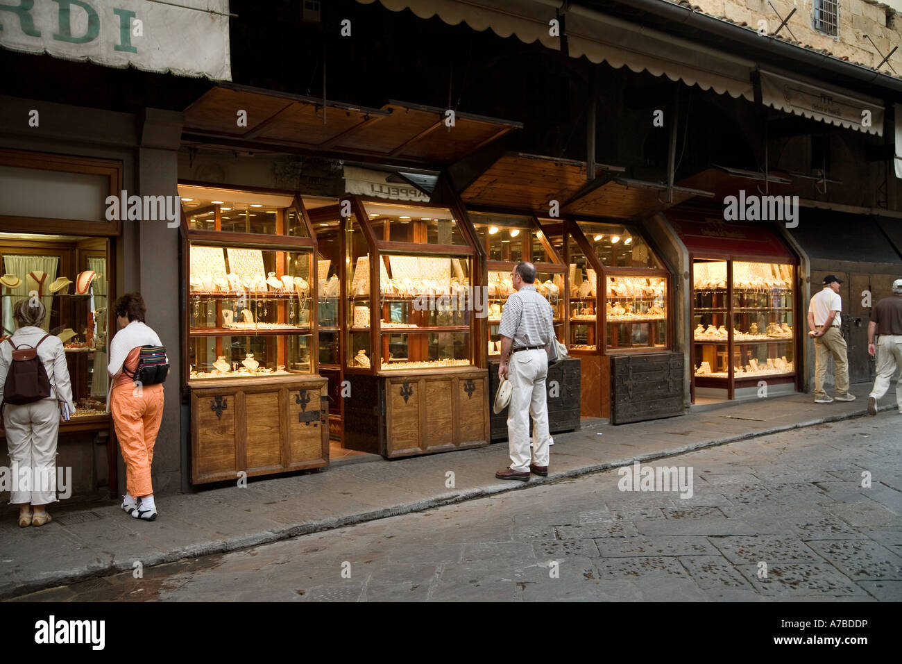 I potenziali clienti lo sguardo in windows di alcuni dei molti negozi di gioielli aperto sul Ponte Vecchio a Firenze Italia Foto Stock