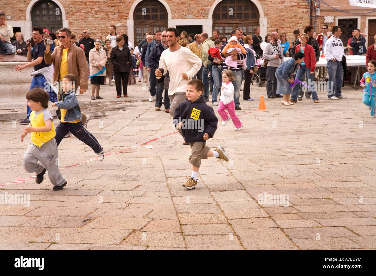 I bambini corrono in street race come parte del festival in merletto isola di Venezia famosa per i suoi merletti non rilasciato Foto Stock