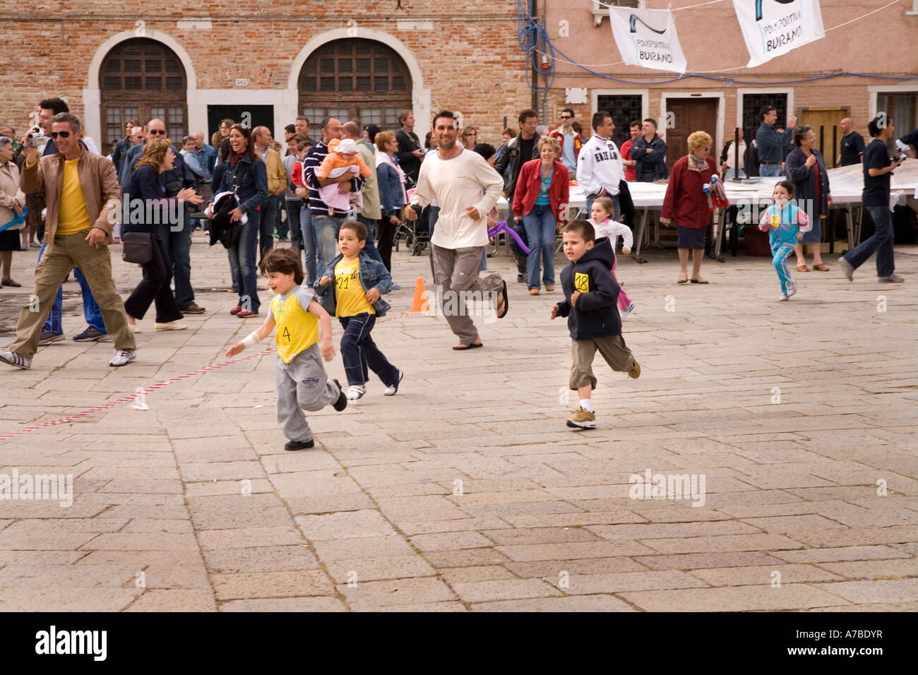 I bambini corrono in street race come parte del festival in merletto isola di Venezia Foto Stock