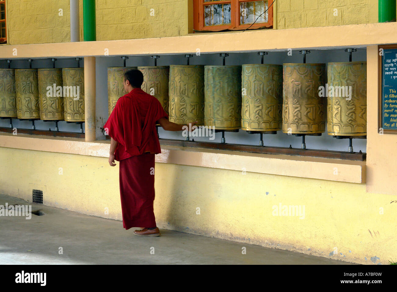 Monaco ruotando la ruota di preghiera a tsuglagkhang Foto Stock