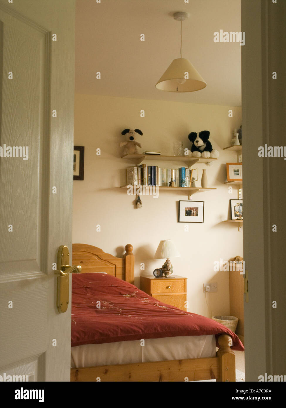 Vista attraverso una porta della camera da letto con letto matrimoniale e mobili all'interno di una casa Foto Stock