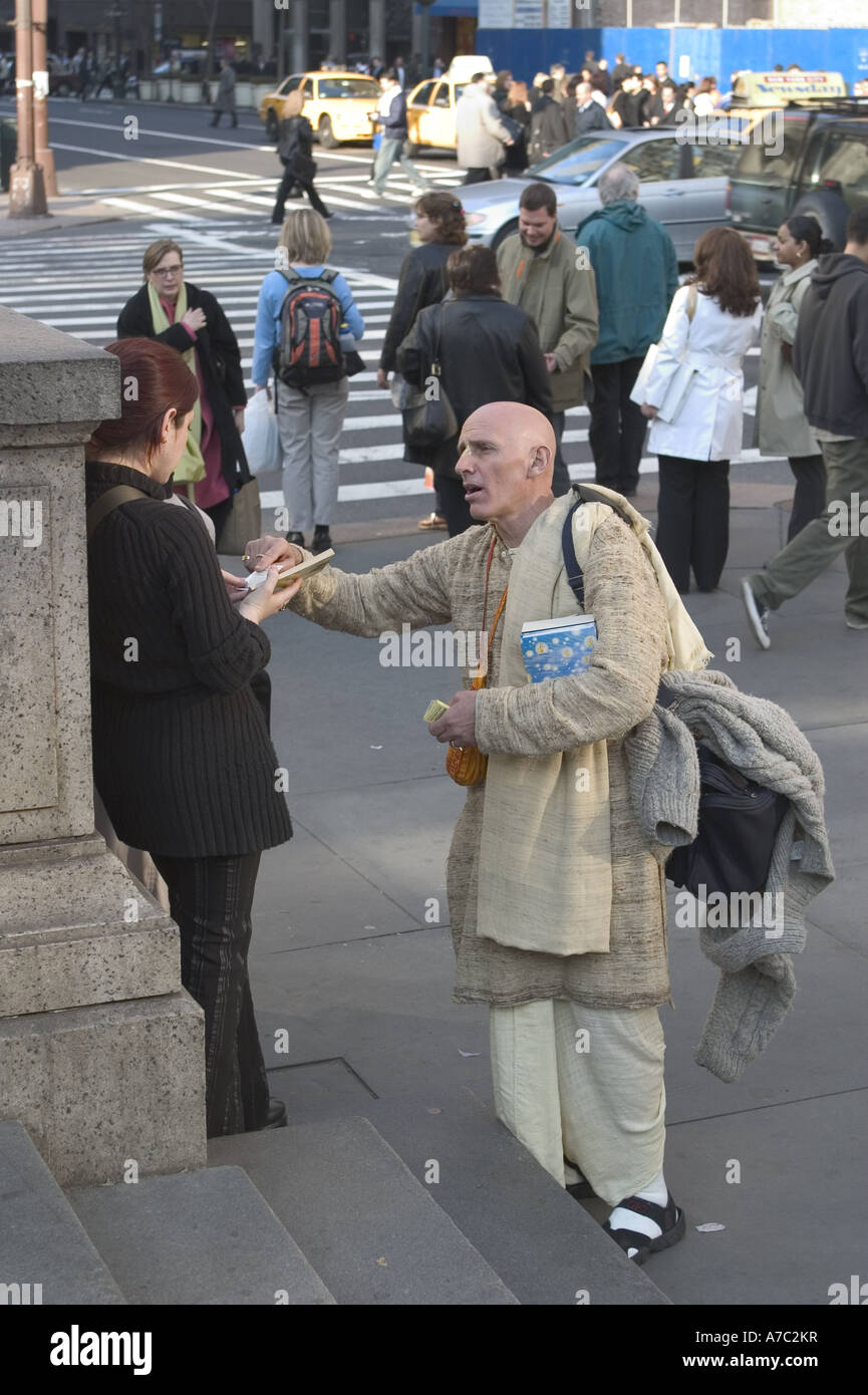 Hari Krishna devoto passando dalla letteratura nella parte anteriore della Biblioteca Pubblica di New York a 42nd St e 5th Avenue a Manhattan Foto Stock