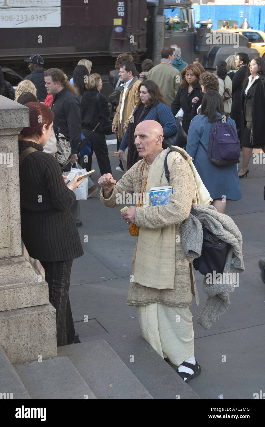 Hari Krishna devoto passando dalla letteratura nella parte anteriore della Biblioteca Pubblica di New York a 42nd St e 5th Avenue a Manhattan Foto Stock