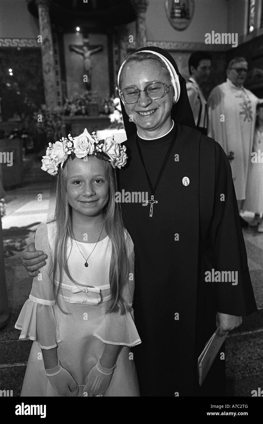 Nun con la giovane ragazza alla sua prima comunione nella Chiesa cattolica Foto Stock