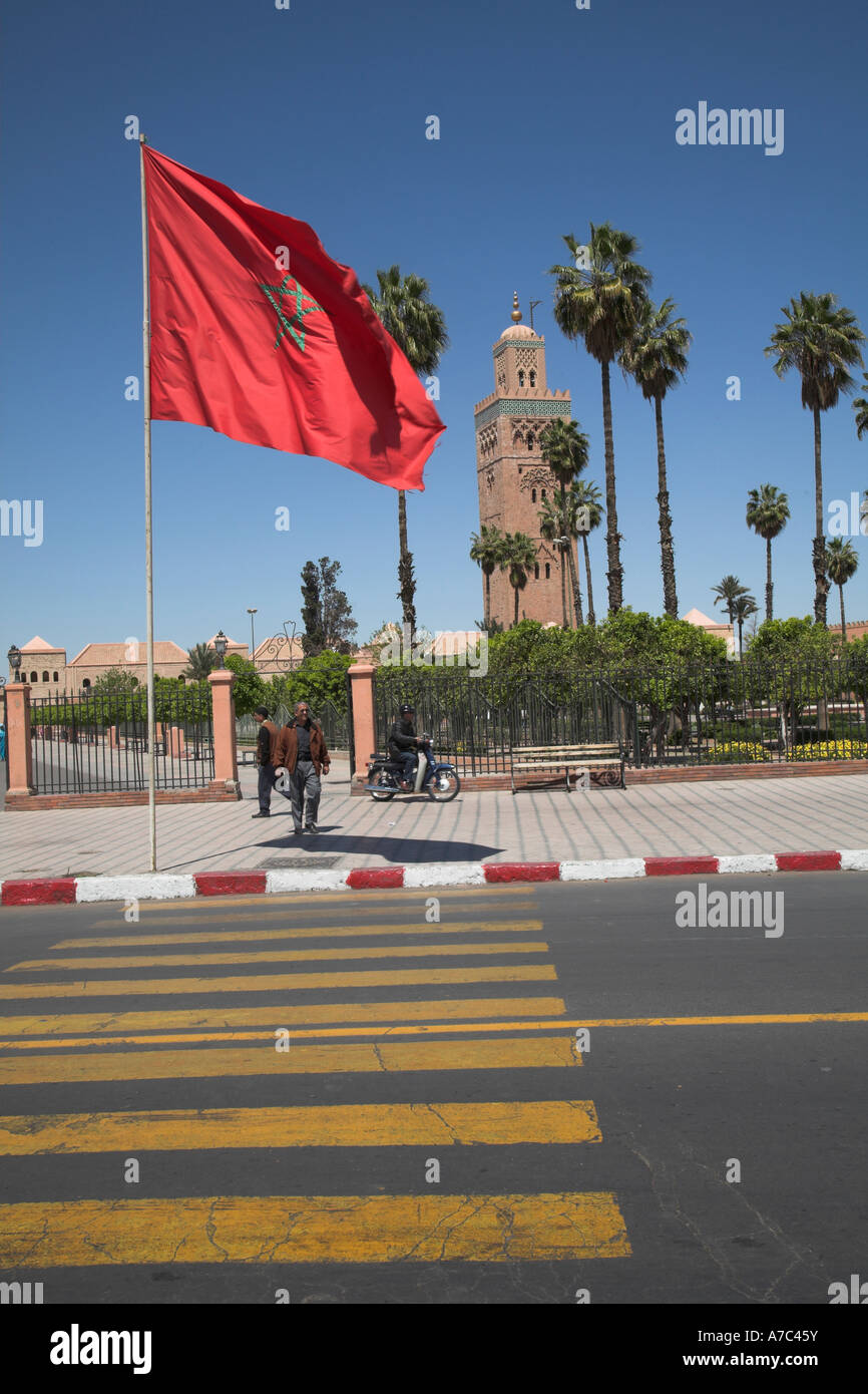 Rosso grande bandiera marocchina battenti dalla moschea di Koutoubia Marrakech, Marocco, Africa del nord Foto Stock