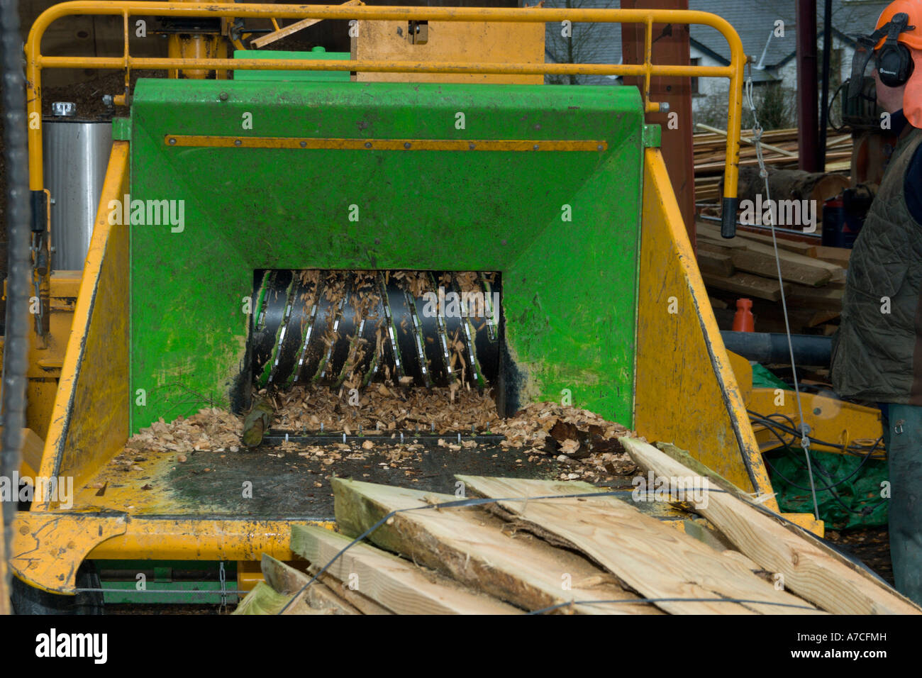 Truciolo essendo preparato da rifiuti slabwood per caldaie per il  riscaldamento centrale con un trattore alimentato chipping macchina, Galles  Foto stock - Alamy