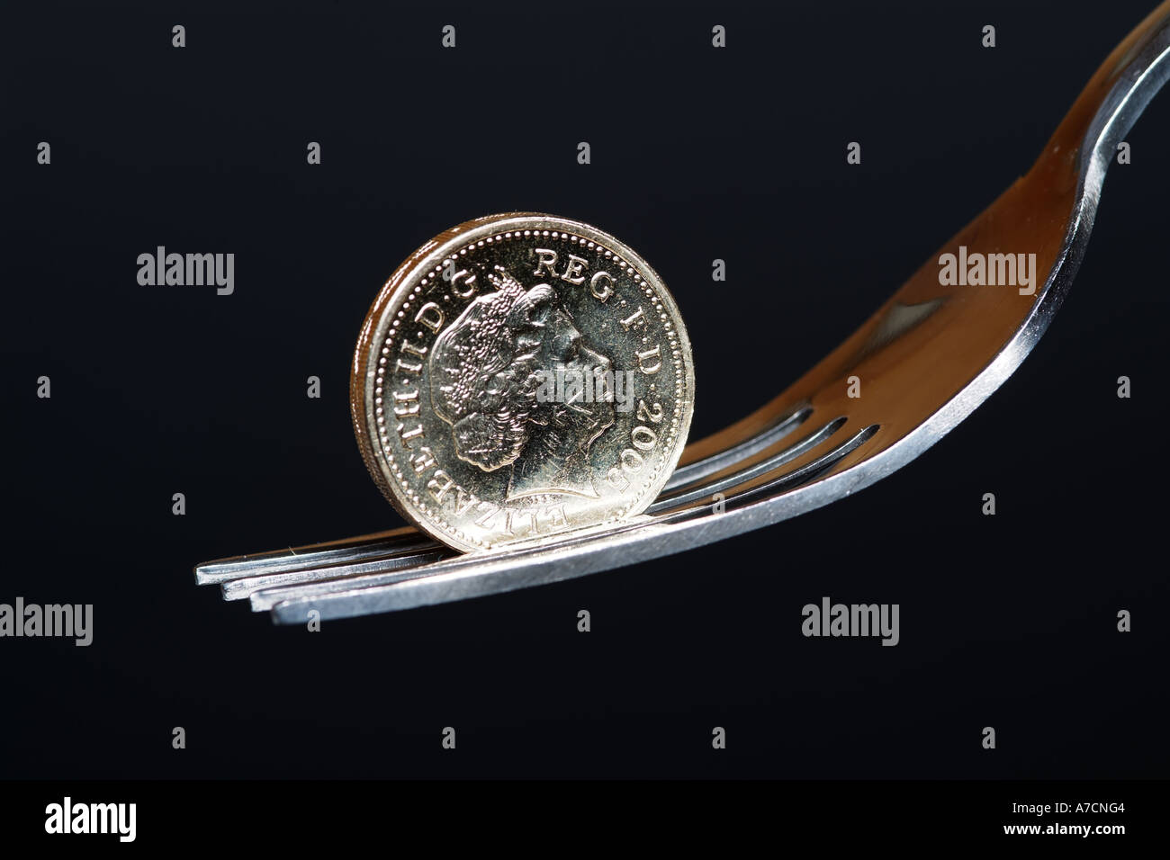 Una libbra di monete in equilibrio su un colore argento forcella Foto Stock