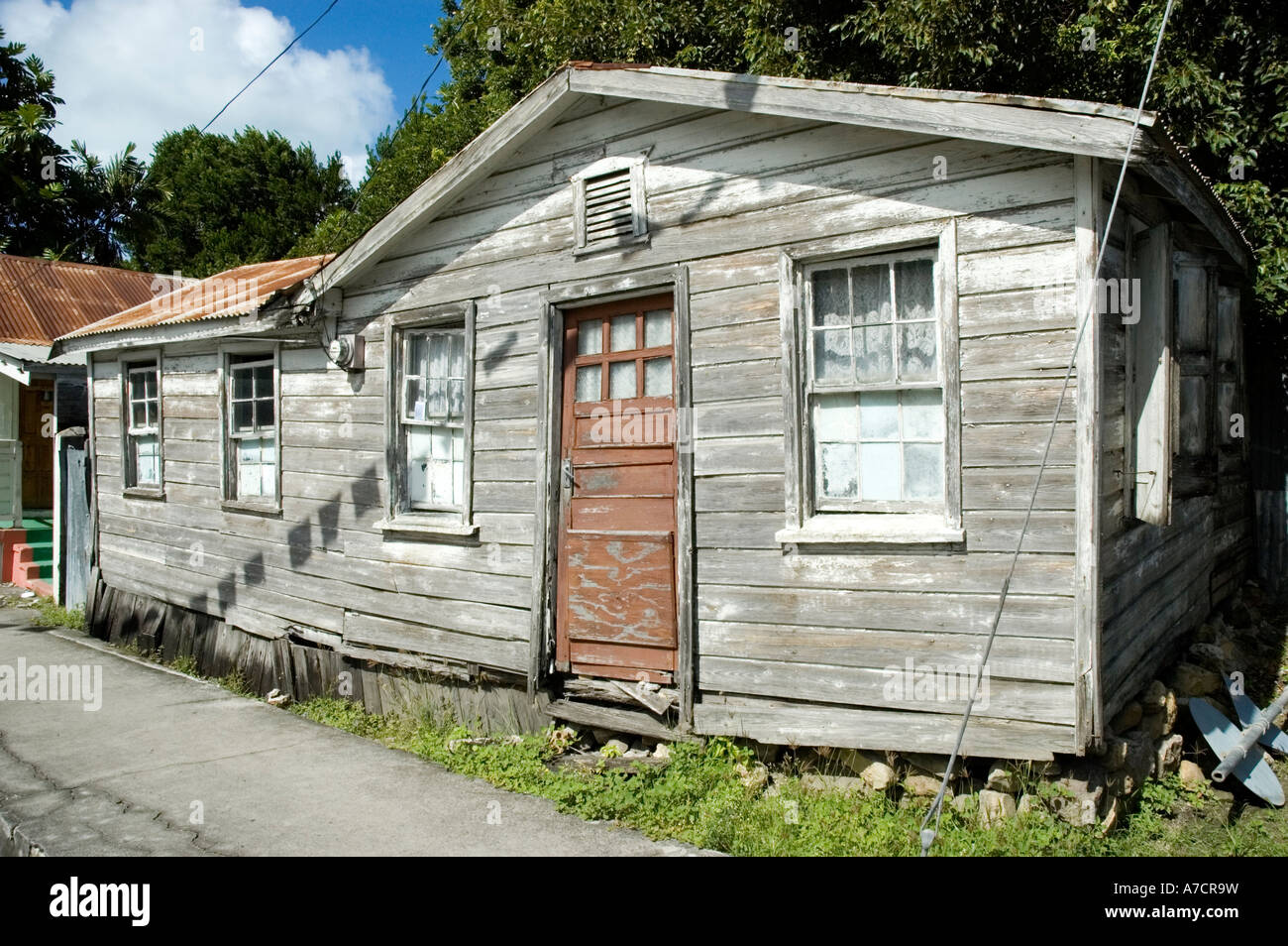 Una vecchia casa clapboard con un ferro corrugato tetto sbiancato per un grigio opaco dal caldo sole tropicale, St John's, Antigua Foto Stock