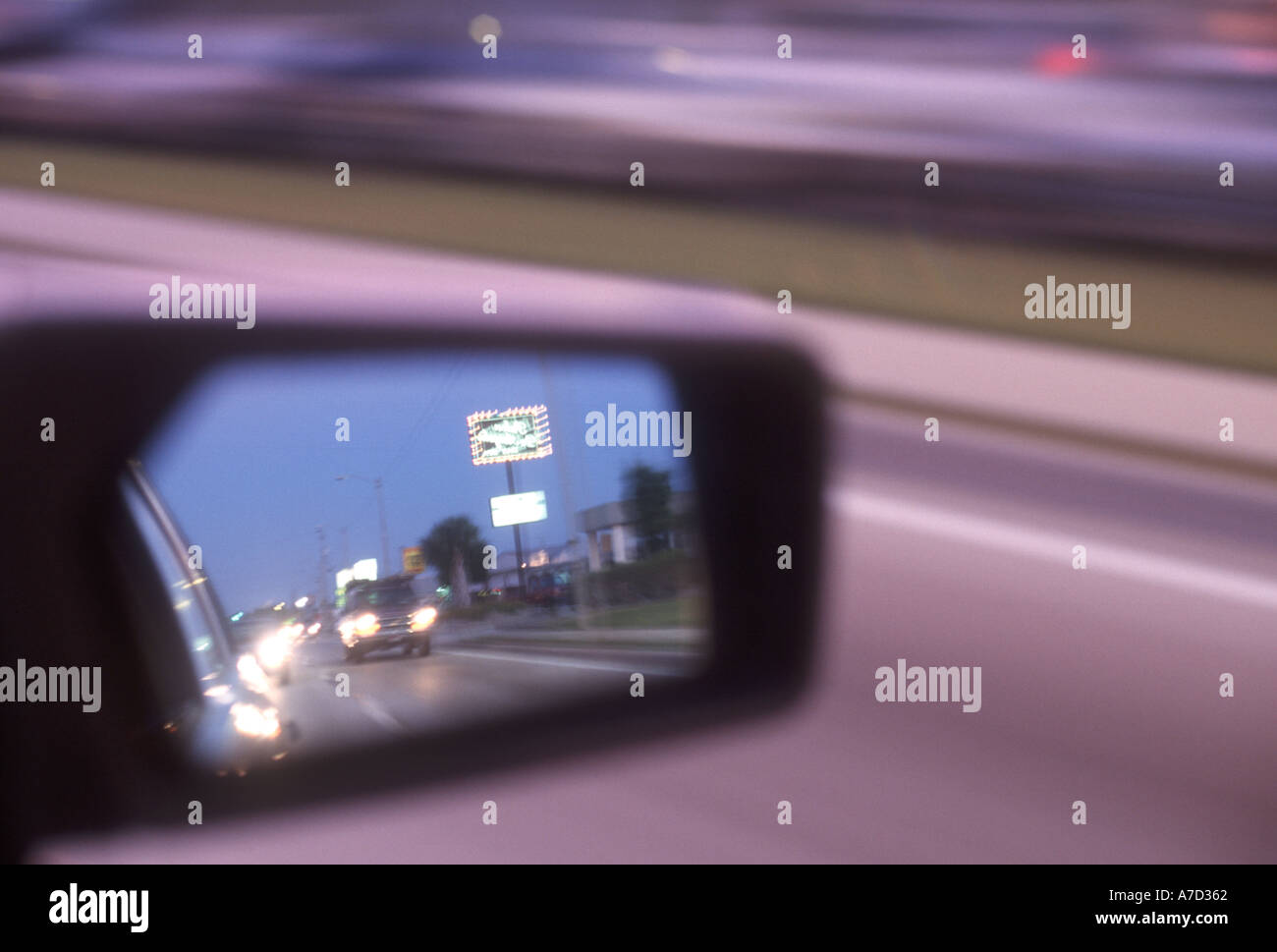 Lato auto specchio riflettendo sera il traffico su strada Foto Stock