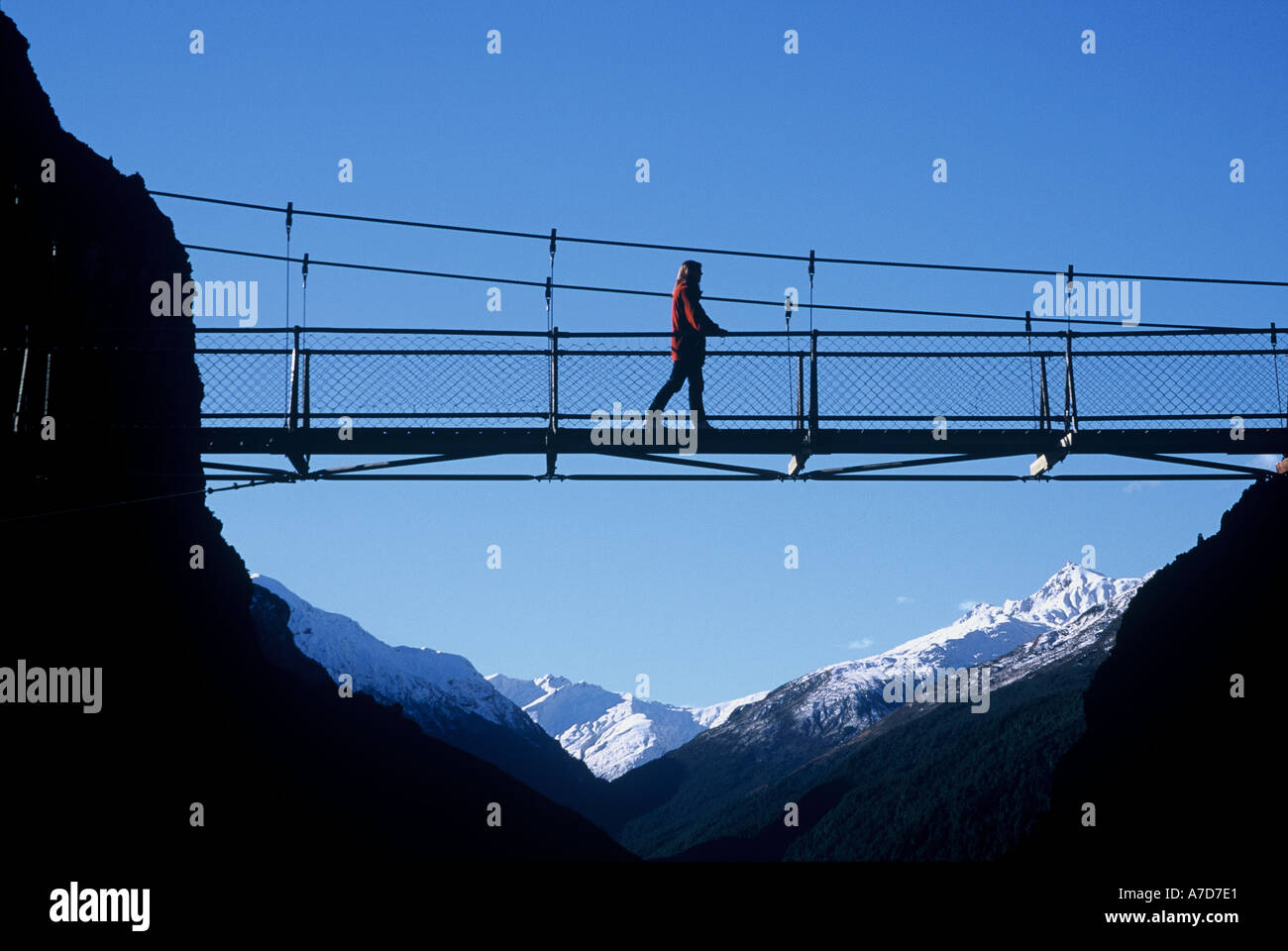 Escursionista filo ponte sul fiume Matukituki vicino a Mt Aspiring Ntional parco vicino a Wanaka Nuova Zelanda Foto Stock