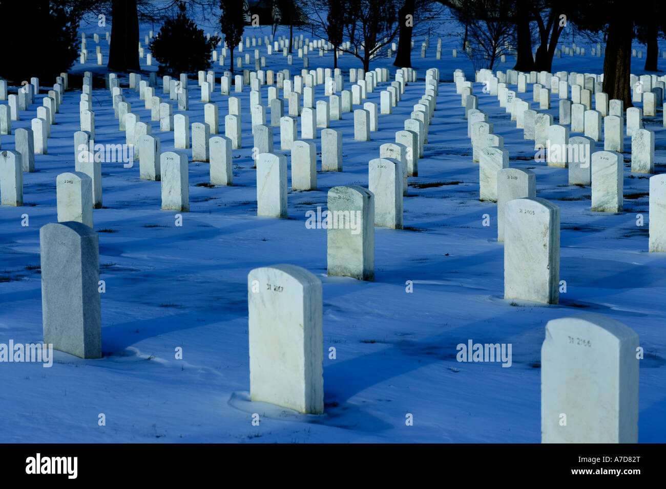 Righe di lapidi in Al Cimitero Nazionale di Arlington nella neve durante la notte. Washington DC VA USA US Foto Stock