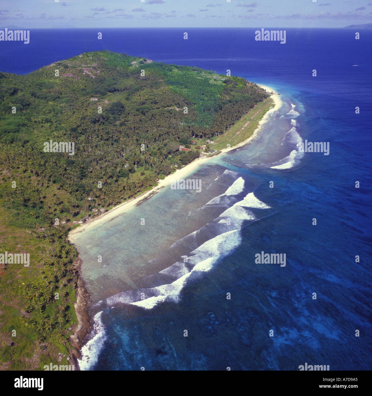 Vista aerea della spiaggia di sabbia bianca con il surf rompe sulla barriera corallina poco profonda di isola deserta fregata in stile isola delle Seychelles Foto Stock