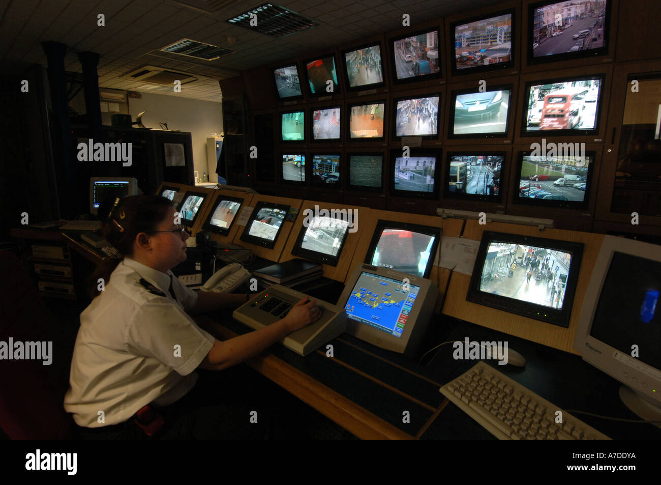 Un operatore TVCC a Brighton stazione di polizia controlla una banca di schermate che mostrano le immagini provenienti da telecamere CCTV monitoring le strade Foto Stock