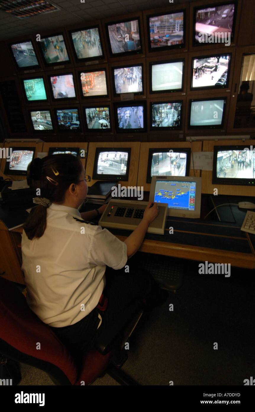 Un operatore TVCC a Brighton stazione di polizia controlla una banca di schermi da telecamere CCTV monitoring per le strade della città Foto Stock