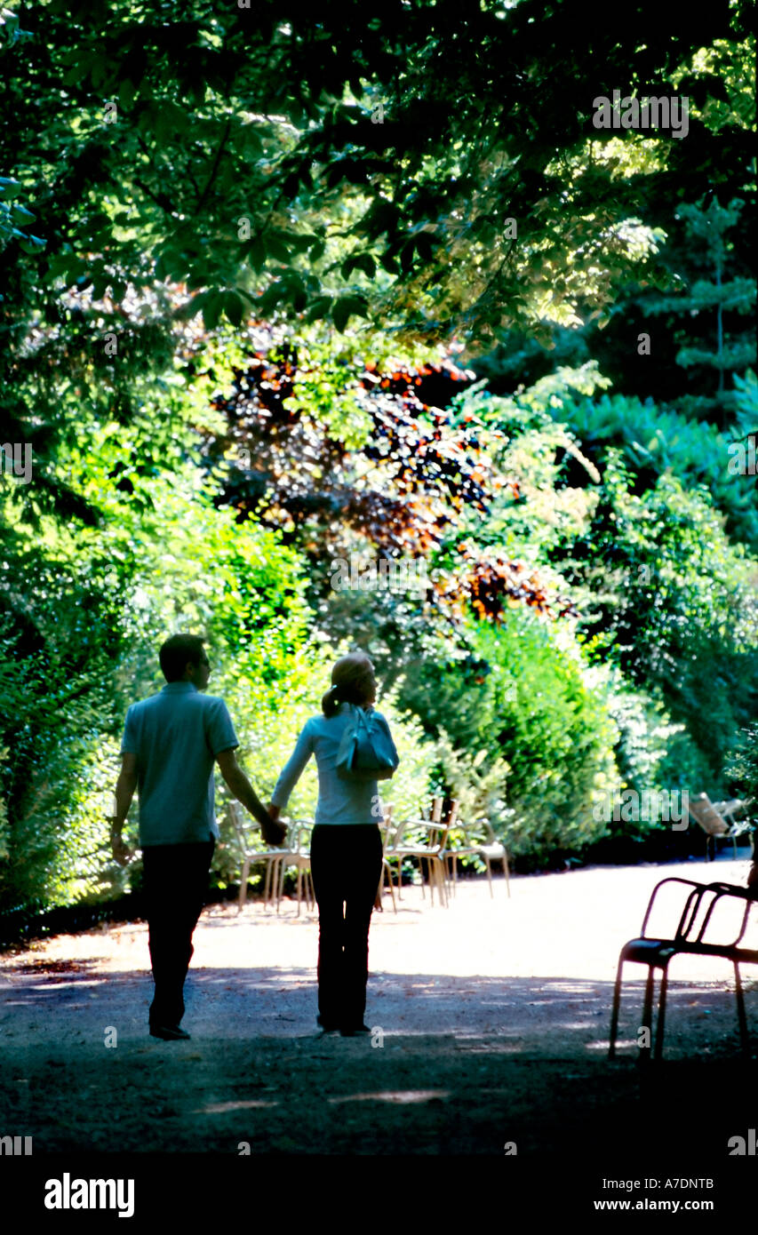Parigi romantica Francia, Parchi Coppia giovane di adolescenti turisti adolescente Camminano mano nella mano nel "Jardin du Luxembourg" "Luxembourg Gardens" in primavera Foto Stock