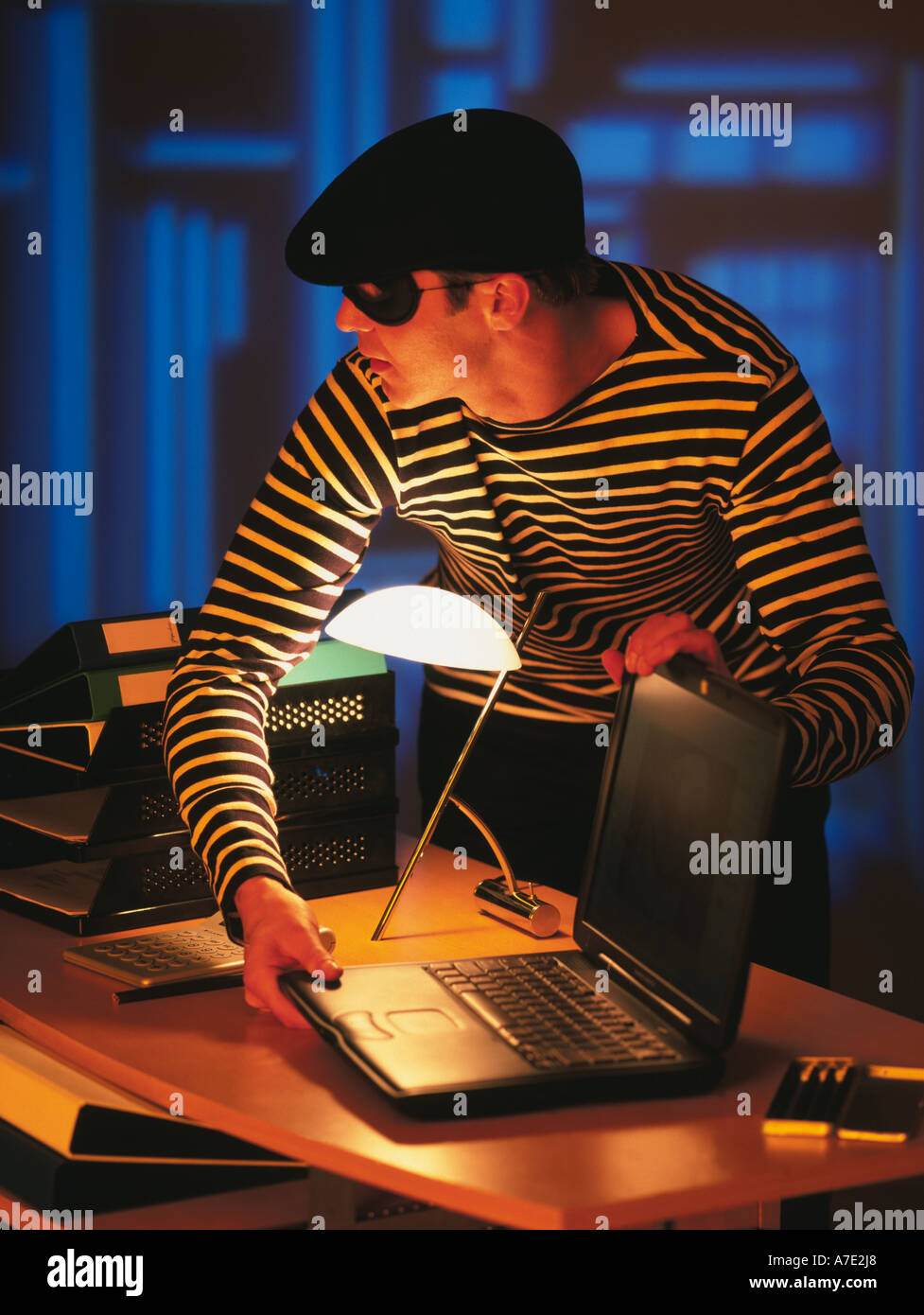 Ladro in costume tradizionale,ladro rubare un computer portatile Foto Stock