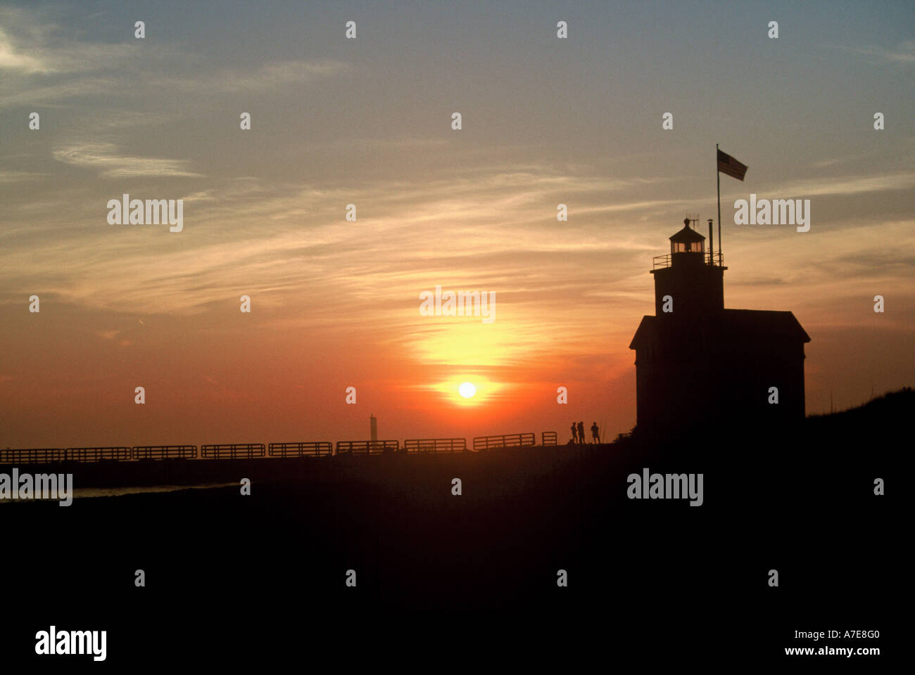 La gente sulla struttura di frangionde godendo la Holland Michigan faro rosso sulla regione dei Grandi Laghi Foto Stock