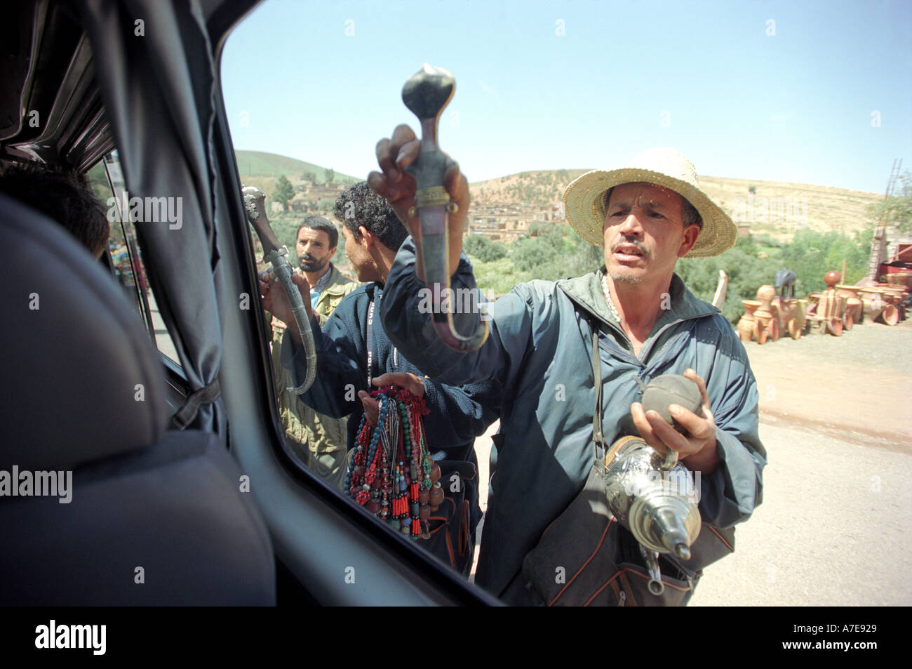 Un venditore ambulante che cerca di vendere un pugnale ad un turista in Marocco in Nord Africa Foto Stock