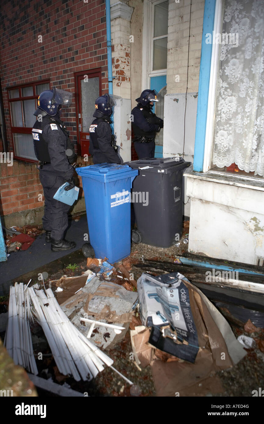 Gli ufficiali di polizia immettere una proprietà durante un'alba raid su sospetti trafficanti di droga a Hull in febbraio 2007 Foto Stock