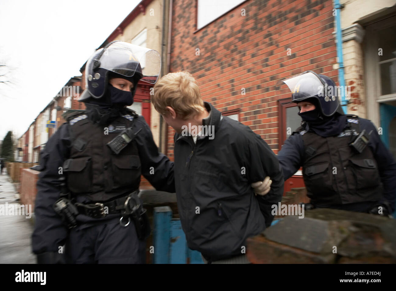 Gli ufficiali di polizia arresti e portare via un sospetto di droga il concessionario a seguito di un'alba raid su proprietà in Hull Febbraio 2007 Foto Stock